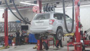 Mechanics lift a car to repair it.