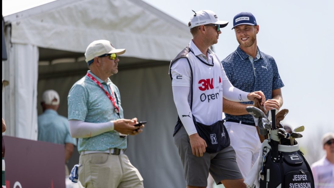 A golfer and his caddie at last year's 3M Open golf tournament.
