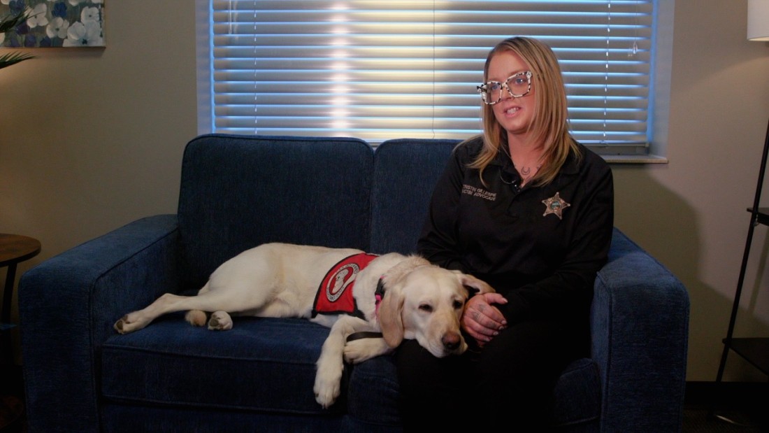 Sedona, the new Sheriff's Department service dog, relaxes on the lap of her handler.